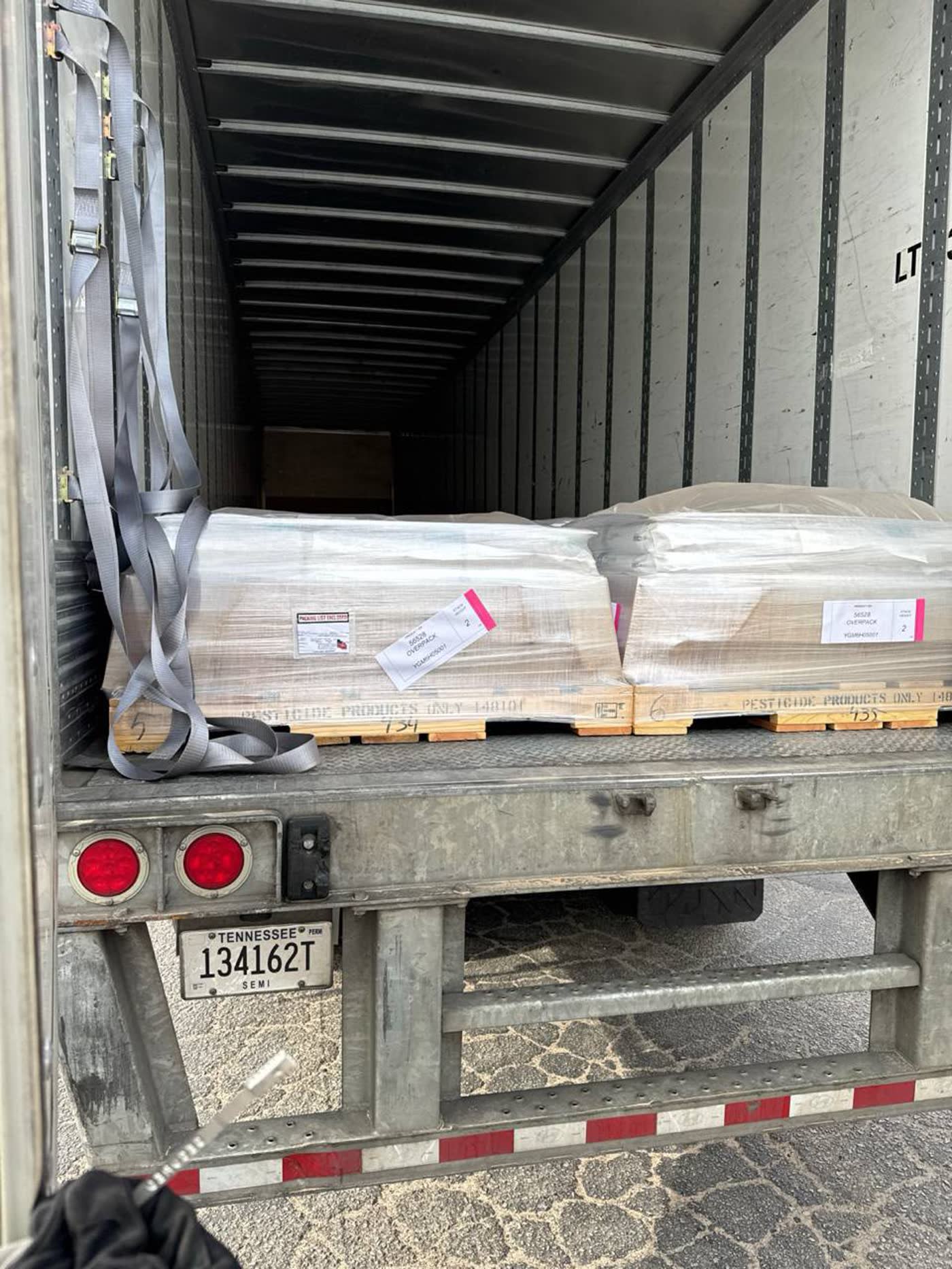 Palletised freight strapped down inside a Zaza Transport 53 ft dry van trailer with the doors open.